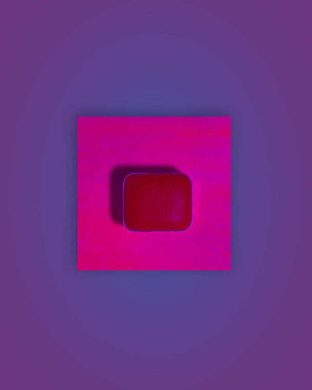 Acuarela individual fluorescente Fucsia en halfpan mostrando su reacción bajo luz UV sobre fondo blanco