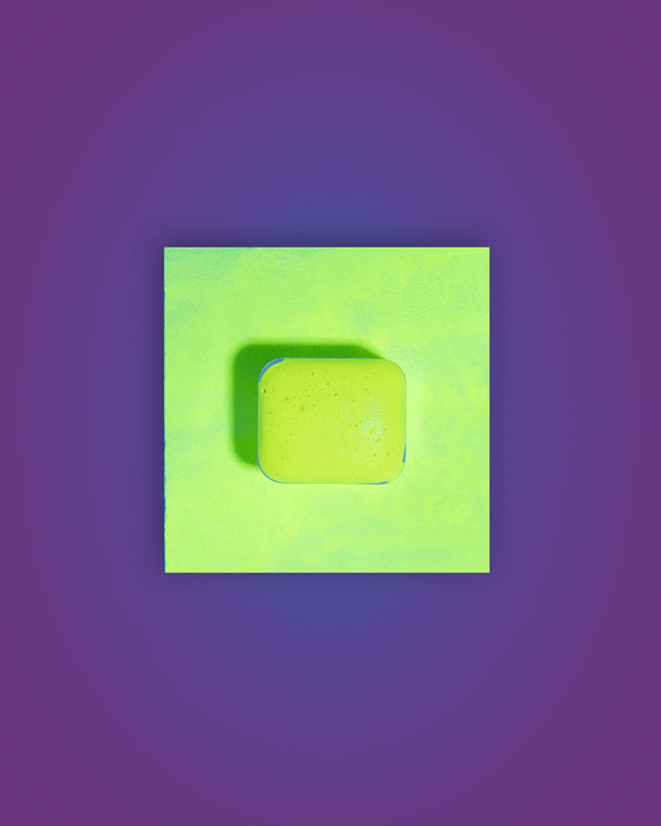 Acuarela individual fluorescente Limón en halfpan mostrando su reacción bajo luz UV sobre fondo blanco